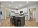 Bright kitchen features white cabinets, a center island with bar stools and modern appliances at 22 Chapman Ct, Wendell, NC 27591