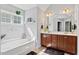 Bright bathroom featuring double sinks, a soaking tub, and modern lighting at 2207 Wimberly Woods Dr, Sanford, NC 27330