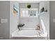 Relaxing bathroom featuring a soaking tub, white trim, and a sunny window at 2207 Wimberly Woods Dr, Sanford, NC 27330