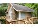 Exterior view of the home featuring a stone chimney and wood deck at 222 Sagamore Dr, Louisburg, NC 27549