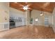 Open-concept living room with hardwood floors, light yellow walls, and vaulted wood ceiling into kitchen at 222 Sagamore Dr, Louisburg, NC 27549