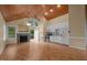 Spacious living area featuring wood floors, fireplace, vaulted ceiling, and bright kitchen at 222 Sagamore Dr, Louisburg, NC 27549