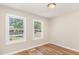 Bright bedroom featuring wood floors, neutral paint, and natural light from two windows at 2312 Shannon St, Raleigh, NC 27610