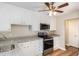 Updated kitchen with white cabinetry, granite countertops, stainless steel appliances and laminate flooring at 2312 Shannon St, Raleigh, NC 27610