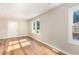 Bright living room with newly installed hardwood floors and fresh paint, illuminated by natural light from windows at 2312 Shannon St, Raleigh, NC 27610
