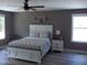 Serene bedroom features a cozy bed with a ceiling fan and ample natural light at 249 Fisherman Point Rd, Roxboro, NC 27574