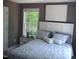 Cozy bedroom featuring a comfortable bed with bright, natural light from the window and neutral wall color at 249 Fisherman Point Rd, Roxboro, NC 27574