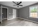 Well lit bedroom with luxury vinyl plank flooring, modern paint, ceiling fan and window at 249 Fisherman Point Rd, Roxboro, NC 27574