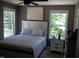 Bright bedroom featuring a comfortable bed, two windows with bright, natural light and neutral wall color at 249 Fisherman Point Rd, Roxboro, NC 27574