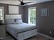 Bedroom featuring a comfortable bed, white trim, and natural light from two windows at 249 Fisherman Point Rd, Roxboro, NC 27574