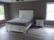 Spacious bedroom features a large bed, side table, and natural light from two windows at 249 Fisherman Point Rd, Roxboro, NC 27574