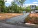 Long gravel driveway leading to a charming lakeside home with a partially wooded lot at 249 Fisherman Point Rd, Roxboro, NC 27574