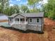 Charming one-story home exhibiting gray siding, a stone foundation, and a welcoming front porch with red door at 249 Fisherman Point Rd, Roxboro, NC 27574