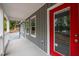Inviting front porch featuring a vibrant red door, gray siding, and white trim details at 249 Fisherman Point Rd, Roxboro, NC 27574