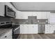 Bright kitchen with stainless steel appliances, granite countertops, and modern white cabinetry with stainless fixtures at 249 Fisherman Point Rd, Roxboro, NC 27574