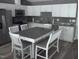 This kitchen features white cabinets, stainless steel appliances, and seating for four at 249 Fisherman Point Rd, Roxboro, NC 27574
