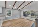 Hardwood floors with a view to the backyard, fireplace, vaulted ceilings with beams, and recessed lighting at 2600 Wade Ave, Raleigh, NC 27607