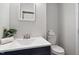 Bathroom features a white vanity with modern fixtures, a mirror, and a toilet with stacked towels at 2835 Bedfordshire Ct, Raleigh, NC 27604