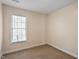 Bedroom showcasing neutral walls and carpet, a window with natural light, and baseboard molding at 2835 Bedfordshire Ct, Raleigh, NC 27604