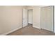 Bedroom with neutral walls and carpet, two doors, baseboard molding, and a closet with doors at 2835 Bedfordshire Ct, Raleigh, NC 27604