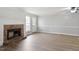 Bright living room has wood floor and a brick fireplace with a white mantle and a glass-paneled door at 2835 Bedfordshire Ct, Raleigh, NC 27604