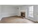 Living room with wood floor, brick fireplace, built-in shelves, and a window with natural light at 2835 Bedfordshire Ct, Raleigh, NC 27604