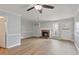 Spacious living room features wood flooring, a brick fireplace, built-in shelving, and a ceiling fan at 2835 Bedfordshire Ct, Raleigh, NC 27604