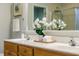 Bathroom vanity with double sinks and white orchids adds elegance to the space at 303 Laurens Way, Chapel Hill, NC 27516