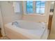 Soaking tub with a shower, window, and modern fixtures at 303 Laurens Way, Chapel Hill, NC 27516