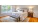 Comfortable bedroom with a large window for ample natural light, wood floors, and a neutral color palette at 303 Laurens Way, Chapel Hill, NC 27516