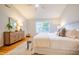 A primary suite featuring a ceiling fan and a large window overlooking the front yard at 303 Laurens Way, Chapel Hill, NC 27516