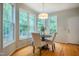 Sunlit breakfast nook features a modern light fixture and large windows with wooded views at 303 Laurens Way, Chapel Hill, NC 27516