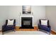 Elegant fireplace with a white mantle and dark stone hearth, flanked by two armchairs at 303 Laurens Way, Chapel Hill, NC 27516