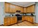 Kitchen with stainless steel gas range, stone countertops, and wooden cabinetry at 303 Laurens Way, Chapel Hill, NC 27516