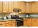 Bright kitchen includes a stainless steel gas range, stone countertops and wood cabinetry at 303 Laurens Way, Chapel Hill, NC 27516