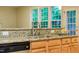 Close-up of kitchen counter, wooden cabinets, and stainless steel sink with bar in the background at 303 Laurens Way, Chapel Hill, NC 27516