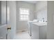 Practical laundry room featuring a washer, dryer, shelving, and window for natural light at 303 Laurens Way, Chapel Hill, NC 27516