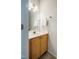 Half bathroom with white vanity, wood cabinets, and a large mirror at 303 Laurens Way, Chapel Hill, NC 27516