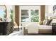 Sunlit bedroom features a plush bed, dark dresser, and windows overlooking a lush yard at 308 Canyon Spring Trl, Wake Forest, NC 27587