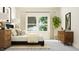 Modern bedroom boasting a large window, decorative plant and a stylish dark-wood dresser at 308 Canyon Spring Trl, Wake Forest, NC 27587