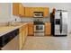 Well-equipped kitchen featuring stainless steel appliances, light wood cabinets, and tiled floors at 3108 Forrestal Dr, Durham, NC 27703