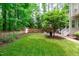 Fenced backyard with green lawn, a patio, and lush trees offer privacy and space for outdoor enjoyment at 3304 Rockland Ridge Dr, Cary, NC 27519