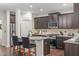 Modern kitchen with dark cabinetry, stainless steel appliances, and granite countertops, including a kitchen island with seating at 3304 Rockland Ridge Dr, Cary, NC 27519