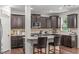 A well-equipped kitchen with stainless steel appliances, dark cabinets, tile backsplash and granite countertops with barstool seating at 3304 Rockland Ridge Dr, Cary, NC 27519