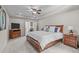 Spacious primary bedroom with neutral tones, large bed, tray ceiling, and a doorway to the ensuite bathroom at 3304 Rockland Ridge Dr, Cary, NC 27519