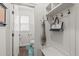 Bright mudroom with white walls, storage hooks, bench, and a glimpse into the adjacent powder room at 3304 Rockland Ridge Dr, Cary, NC 27519