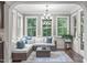 Bright sunroom with large windows, comfortable seating, and a view of the surrounding greenery at 3304 Rockland Ridge Dr, Cary, NC 27519