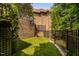Fenced backyard featuring lush artificial turf and a brick retaining wall, offering a private and well-maintained outdoor space at 3601 Nightfall Ct, Raleigh, NC 27607