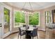 Bright dining area with a modern chandelier, elegant table and chairs, and beautiful backyard views at 3601 Nightfall Ct, Raleigh, NC 27607