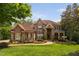 Beautiful brick and stone home with lush landscaping, a charming fountain, and a well-manicured lawn at 3601 Nightfall Ct, Raleigh, NC 27607